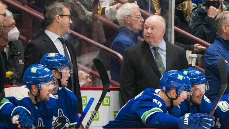 Dec 6, 2021; Vancouver, British Columbia, CAN; Vancouver assistant coach Scott Walker and head coach Bruce Boudreau on the bench during a game against the Los Angeles Kings in the first period at Rogers Arena. Mandatory Credit: Bob Frid-USA TODAY Sports