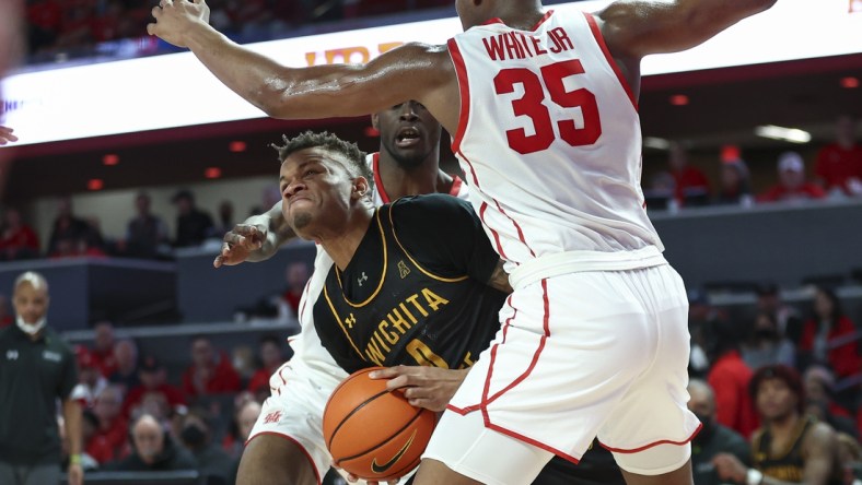 Jan 8, 2022; Houston, Texas, USA; Wichita State Shockers guard Dexter Dennis (0) attempts to control the ball as Houston Cougars forward Fabian White Jr. (35) defends during the second half at Fertitta Center. Mandatory Credit: Troy Taormina-USA TODAY Sports