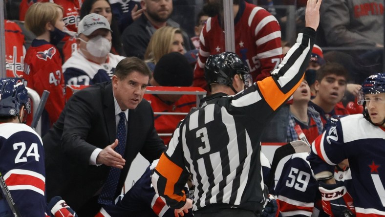 Jan 16, 2022; Washington, District of Columbia, USA; Washington Capitals head coach Peter Laviolette (L) argues a penalty call by referee Mike Leggo (3) during the game against the Vancouver Canucks during the third period at Capital One Arena. Mandatory Credit: Geoff Burke-USA TODAY Sports