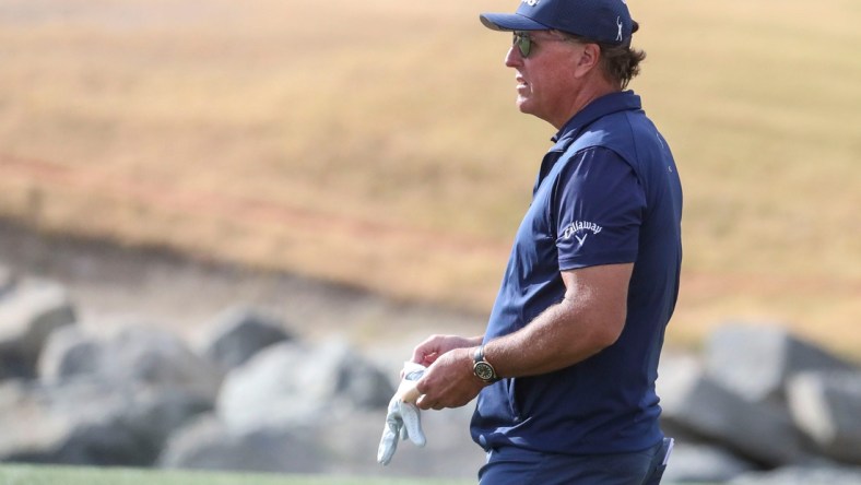 Phil Mickelson gives advice to an amateur in his group while playing the 11th green of the Pete Dye Stadium course during the third round of The American Express at PGA West in La Quinta, Calif., Saturday, Jan. 22, 2022.