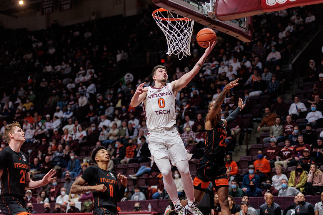 Jan 26, 2022; Blacksburg, Virginia, USA; Virginia Tech Hokies guard Hunter Cattoor (0) shoots over Miami Hurricanes guard Cameron McGusty (23) during the first half at Cassell Coliseum. Mandatory Credit: Ryan Hunt-USA TODAY Sports