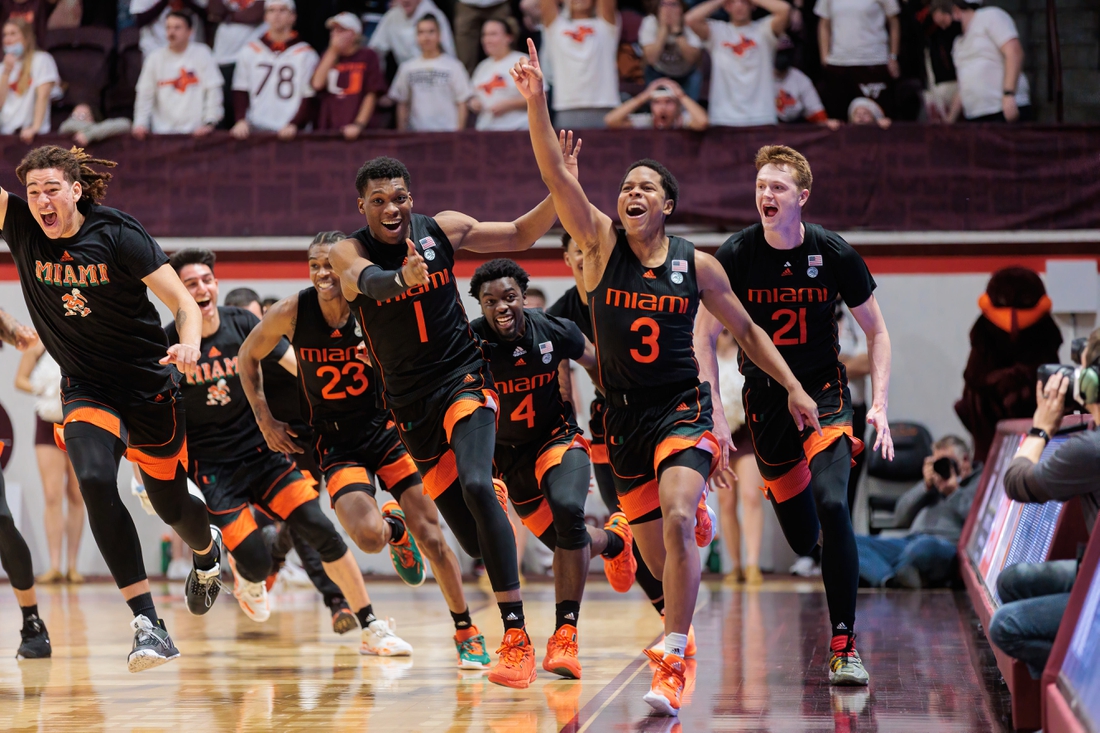 Jan 26, 2022; Blacksburg, Virginia, USA; Miami Hurricanes players celebrate after Charlie Moore   s (3) buzzer beater against Virginia Tech Hokies during the second half at Cassell Coliseum. Mandatory Credit: Ryan Hunt-USA TODAY Sports