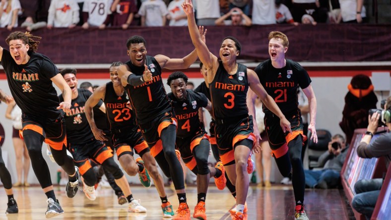 Jan 26, 2022; Blacksburg, Virginia, USA; Miami Hurricanes players celebrate after Charlie Moore   s (3) buzzer beater against Virginia Tech Hokies during the second half at Cassell Coliseum. Mandatory Credit: Ryan Hunt-USA TODAY Sports