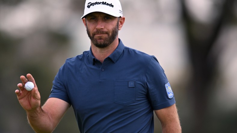 Jan 29, 2022; San Diego, California, USA; Dustin Johnson acknowledges the crowd after a putt on the first green during the final round of the Farmers Insurance Open golf tournament at Torrey Pines Municipal Golf Course - South Course. Mandatory Credit: Orlando Ramirez-USA TODAY Sports