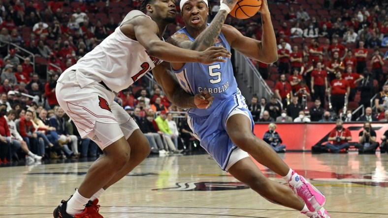 Feb 1, 2022; Louisville, Kentucky, USA;  North Carolina Tar Heels forward Armando Bacot (5) moves to the basket against Louisville Cardinals forward Sydney Curry (21) during the first half at KFC Yum! Center. Mandatory Credit: Jamie Rhodes-USA TODAY Sports