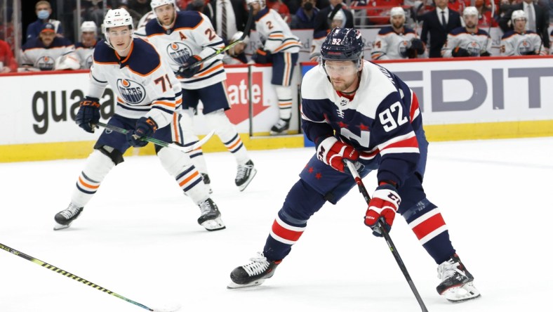 Feb 2, 2022; Washington, District of Columbia, USA; Washington Capitals center Evgeny Kuznetsov (92) skates with the puck as Edmonton Oilers center Ryan McLeod (71) chases during the first period at Capital One Arena. Mandatory Credit: Geoff Burke-USA TODAY Sports