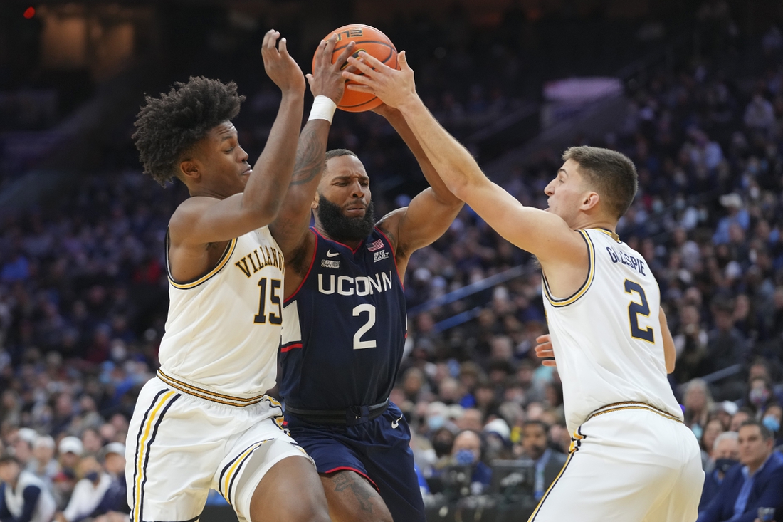 Feb 5, 2022; Philadelphia, Pennsylvania, USA; Connecticut Huskies guard R.J. Cole (2) drives to the basket against Villanova Wildcats guard Jordan Longino (15) and guard Collin Gillespie (2) in the first half at the Wells Fargo Center. Mandatory Credit: Mitchell Leff-USA TODAY Sports