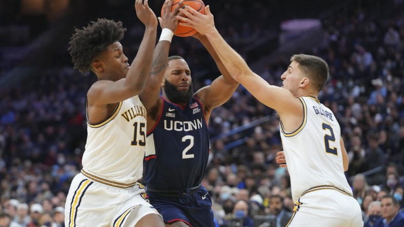 Feb 5, 2022; Philadelphia, Pennsylvania, USA; Connecticut Huskies guard R.J. Cole (2) drives to the basket against Villanova Wildcats guard Jordan Longino (15) and guard Collin Gillespie (2) in the first half at the Wells Fargo Center. Mandatory Credit: Mitchell Leff-USA TODAY Sports