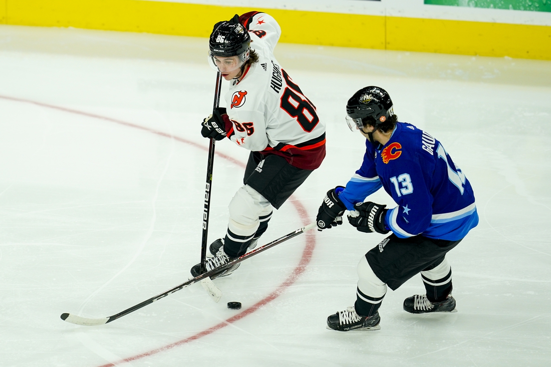 Feb 5, 2022; Las Vegas, Nevada, USA; Metropolitan Division forward Jack Hughes (86) of the New Jersey Devils skates with the puck against Pacific Division forward Johhny Gaudreau (13) of the Calgary Flames during the 2022 NHL All-Star Game at T-Mobile Arena. Mandatory Credit: Lucas Peltier-USA TODAY Sports