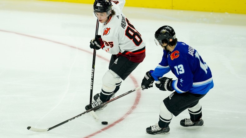 Feb 5, 2022; Las Vegas, Nevada, USA; Metropolitan Division forward Jack Hughes (86) of the New Jersey Devils skates with the puck against Pacific Division forward Johhny Gaudreau (13) of the Calgary Flames during the 2022 NHL All-Star Game at T-Mobile Arena. Mandatory Credit: Lucas Peltier-USA TODAY Sports