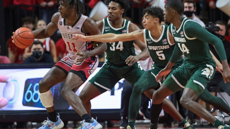 Feb 5, 2022; Piscataway, New Jersey, USA; Rutgers Scarlet Knights center Clifford Omoruyi (11) dribbles as Michigan State Spartans forward Julius Marble II (34) and guard Max Christie (5) and forward Gabe Brown (44) defend during the first half at Jersey Mike's Arena. Mandatory Credit: Vincent Carchietta-USA TODAY Sports