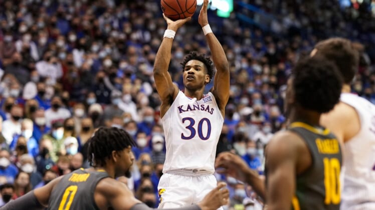 Feb 5, 2022; Lawrence, Kansas, USA; Kansas Jayhawks guard Ochai Agbaji (30) shoots as Baylor Bears forward Flo Thamba (0) and guard Adam Flagler (10) defend during the second half at Allen Fieldhouse. Mandatory Credit: Jay Biggerstaff-USA TODAY Sports