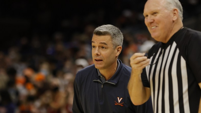 Feb 5, 2022; Charlottesville, Virginia, USA; Virginia Cavaliers head coach Tony Bennett (L) jokes with referee Jamie Luckie (R) against the Miami Hurricanes during the first half at John Paul Jones Arena. Mandatory Credit: Geoff Burke-USA TODAY Sports