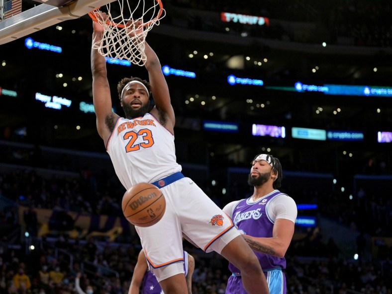 Feb 5, 2022; Los Angeles, California, USA;   New York Knicks center Mitchell Robinson (23) hangs on the rim after a dunk as Los Angeles Lakers forward Anthony Davis (3) looks on in the first quarter of the game at Crypto.com Arena. Mandatory Credit: Jayne Kamin-Oncea-USA TODAY Sports
