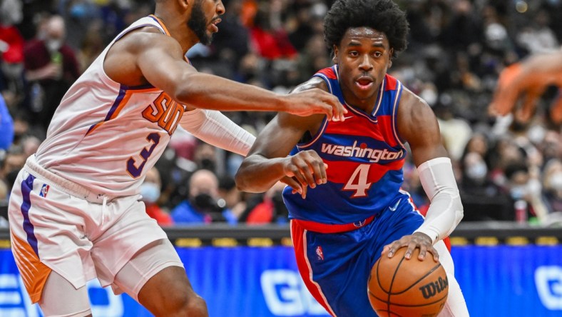 Feb 5, 2022; Washington, District of Columbia, USA; Washington Wizards guard Aaron Holiday (4) dribbles as Phoenix Suns guard Chris Paul (3) defends during the second half at Capital One Arena. Mandatory Credit: Brad Mills-USA TODAY Sports