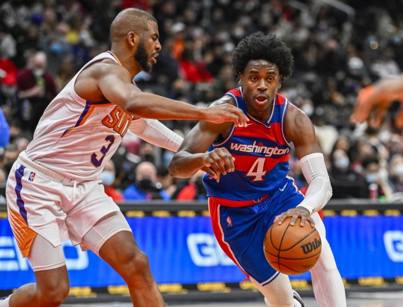 Feb 5, 2022; Washington, District of Columbia, USA; Washington Wizards guard Aaron Holiday (4) dribbles as Phoenix Suns guard Chris Paul (3) defends during the second half at Capital One Arena. Mandatory Credit: Brad Mills-USA TODAY Sports