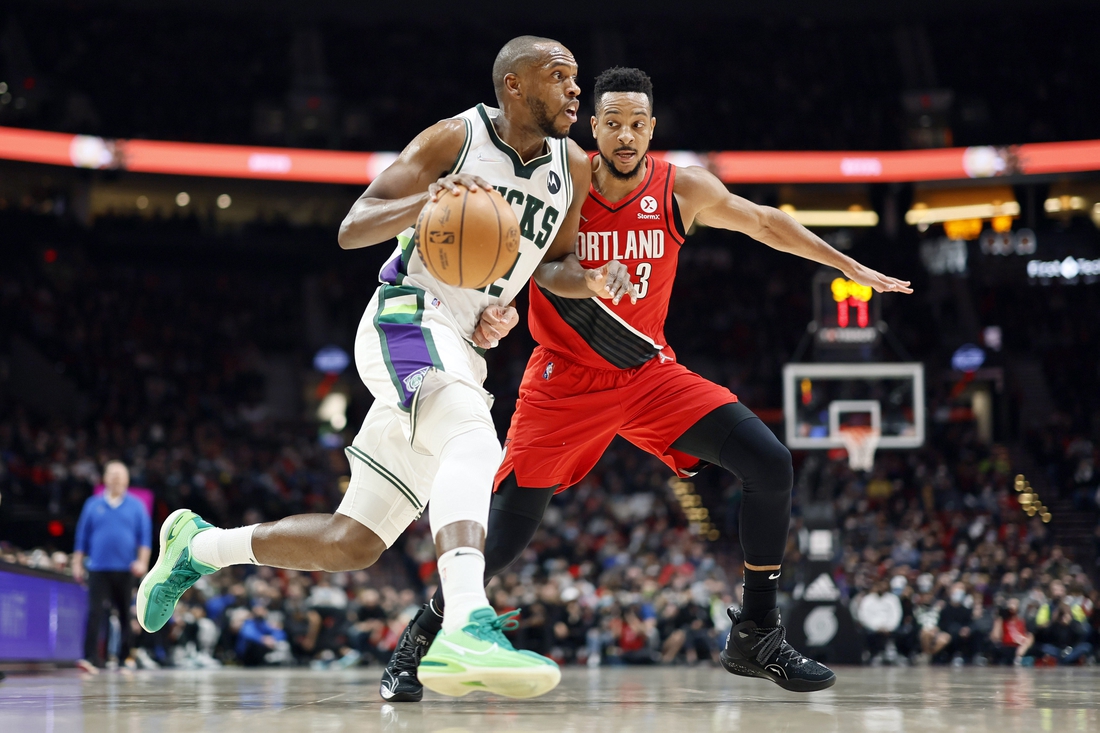 Feb 5, 2022; Portland, Oregon, USA; Milwaukee Bucks small forward Khris Middleton (22) dribbles the ball against Portland Trail Blazers shooting guard CJ McCollum (3) during the first half at Moda Center. Mandatory Credit: Soobum Im-USA TODAY Sports