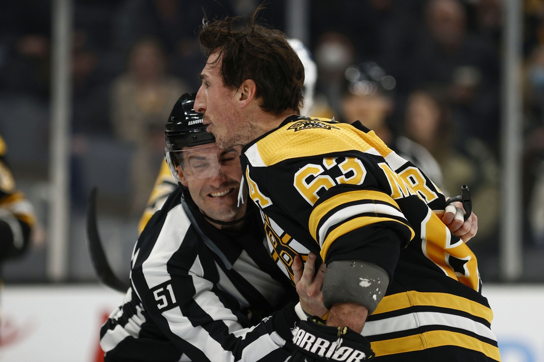 Feb 8, 2022; Boston, Massachusetts, USA; Boston Bruins left wing Brad Marchand (63) is held back by linesman Andrew Smith (51) after he got a penalty for attempting to injure during the third period against the Pittsburgh Penguins at TD Garden. Mandatory Credit: Winslow Townson-USA TODAY Sports