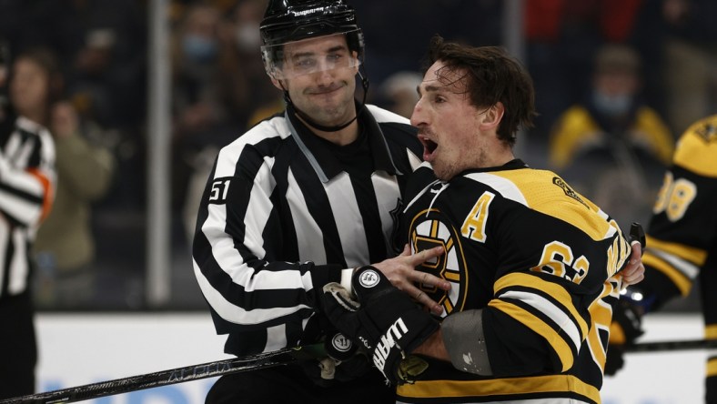 Feb 8, 2022; Boston, Massachusetts, USA; Boston Bruins left wing Brad Marchand (63) is held back by linesman Andrew Smith (51) after he got a penalty for attempting to injure during the third period against the Pittsburgh Penguins at TD Garden. Mandatory Credit: Winslow Townson-USA TODAY Sports