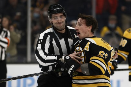 Feb 8, 2022; Boston, Massachusetts, USA; Boston Bruins left wing Brad Marchand (63) is held back by linesman Andrew Smith (51) after he got a penalty for attempting to injure during the third period against the Pittsburgh Penguins at TD Garden. Mandatory Credit: Winslow Townson-USA TODAY Sports