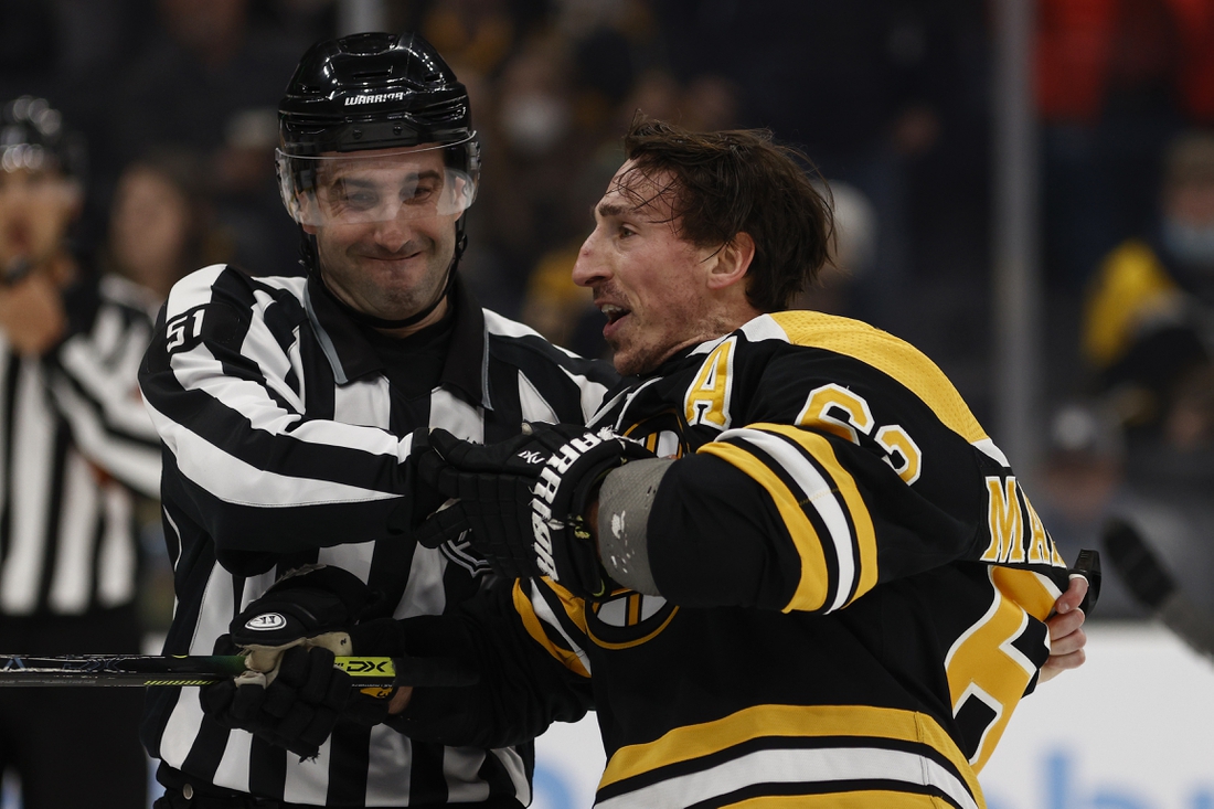 Feb 8, 2022; Boston, Massachusetts, USA; Boston Bruins left wing Brad Marchand (63) is held back by linesman Andrew Smith (51) after he got a penalty for attempting to injure during the third period against the Pittsburgh Penguins at TD Garden. Mandatory Credit: Winslow Townson-USA TODAY Sports