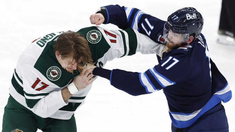 Feb 8, 2022; Winnipeg, Manitoba, CAN; Minnesota Wild left wing Marcus Foligno (17) and Winnipeg Jets center Adam Lowry (17) fight in the third period at Canada Life Centre. Mandatory Credit: James Carey Lauder-USA TODAY Sports