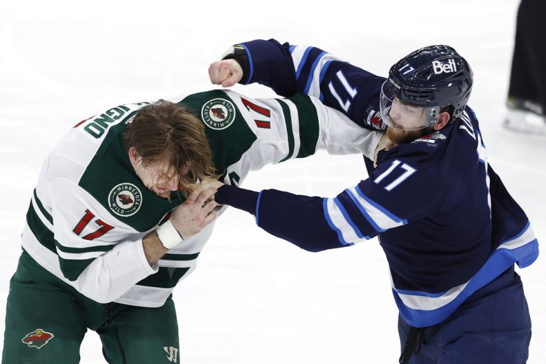 Feb 8, 2022; Winnipeg, Manitoba, CAN; Minnesota Wild left wing Marcus Foligno (17) and Winnipeg Jets center Adam Lowry (17) fight in the third period at Canada Life Centre. Mandatory Credit: James Carey Lauder-USA TODAY Sports