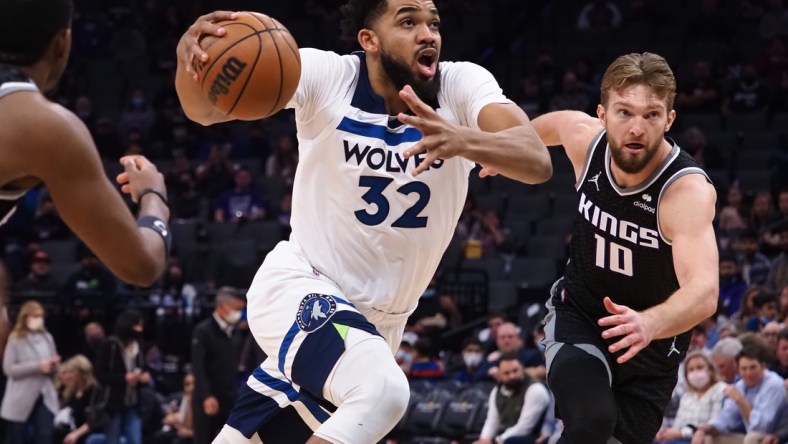 Feb 9, 2022; Sacramento, California, USA; Minnesota Timberwolves center Karl-Anthony Towns (32) drives in against Sacramento Kings center Domantas Sabonis (10) during the first quarter at Golden 1 Center. Mandatory Credit: Kelley L Cox-USA TODAY Sports