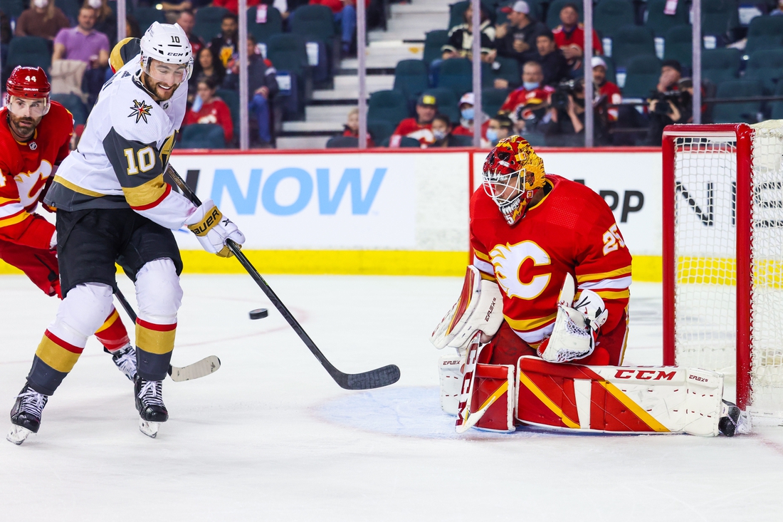 Feb 9, 2022; Calgary, Alberta, CAN; Calgary Flames goaltender Jacob Markstrom (25) makes a save as Vegas Golden Knights center Nicolas Roy (10) tries to score during the second period at Scotiabank Saddledome. Mandatory Credit: Sergei Belski-USA TODAY Sports