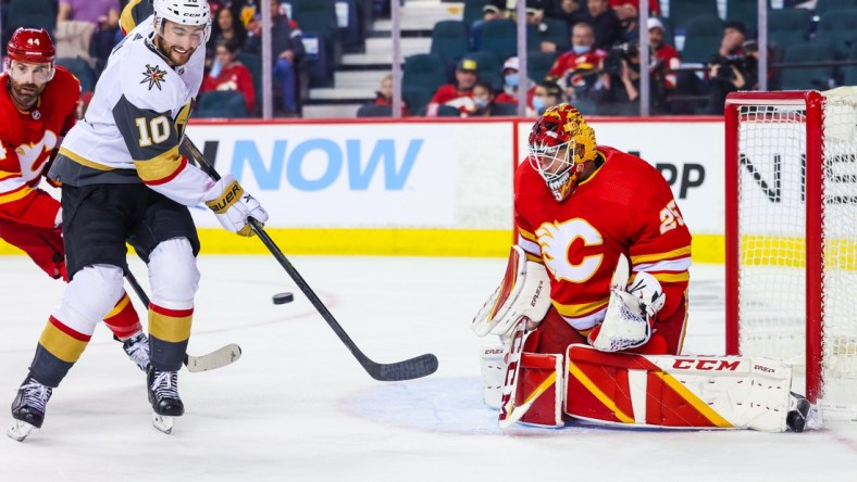 Feb 9, 2022; Calgary, Alberta, CAN; Calgary Flames goaltender Jacob Markstrom (25) makes a save as Vegas Golden Knights center Nicolas Roy (10) tries to score during the second period at Scotiabank Saddledome. Mandatory Credit: Sergei Belski-USA TODAY Sports