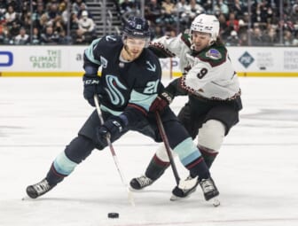 Feb 9, 2022; Seattle, Washington, USA; Seattle Kraken center Alex Wennberg (21) and Arizona Coyotes right wing Clayton Keller (9) battle for a puck during the third period at Climate Pledge Arena. Mandatory Credit: Stephen Brashear-USA TODAY Sports