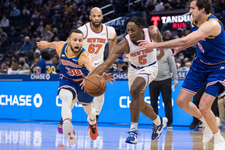 Feb 10, 2022; San Francisco, California, USA; Golden State Warriors guard Stephen Curry (30) and New York Knicks guard Immanuel Quickley (5) scramble for possession during the first half at Chase Center. Mandatory Credit: John Hefti-USA TODAY Sports