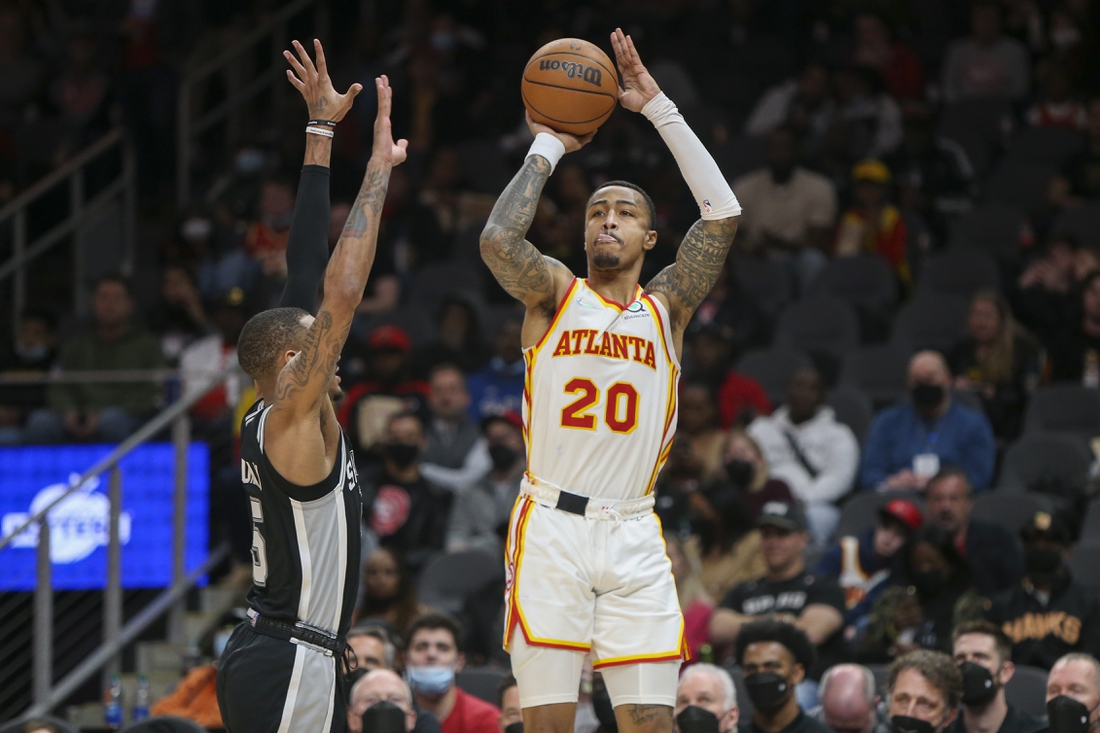 Feb 11, 2022; Atlanta, Georgia, USA; Atlanta Hawks forward John Collins (20) shoots over San Antonio Spurs guard Dejounte Murray (5) in the second half at State Farm Arena. Mandatory Credit: Brett Davis-USA TODAY Sports