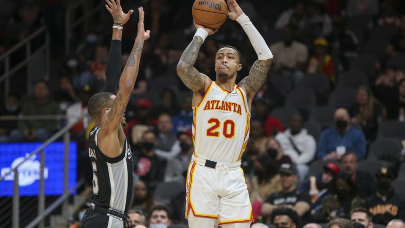 Feb 11, 2022; Atlanta, Georgia, USA; Atlanta Hawks forward John Collins (20) shoots over San Antonio Spurs guard Dejounte Murray (5) in the second half at State Farm Arena. Mandatory Credit: Brett Davis-USA TODAY Sports