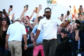Feb 12, 2022; Scottsdale Arizona, USA; Sahith Theegala raises his club after chipping from the rough in the crowd on the 18th hole during Round 3 at the WM Phoenix Open. Mandatory Credit: Patrick Breen-USA TODAY Sports