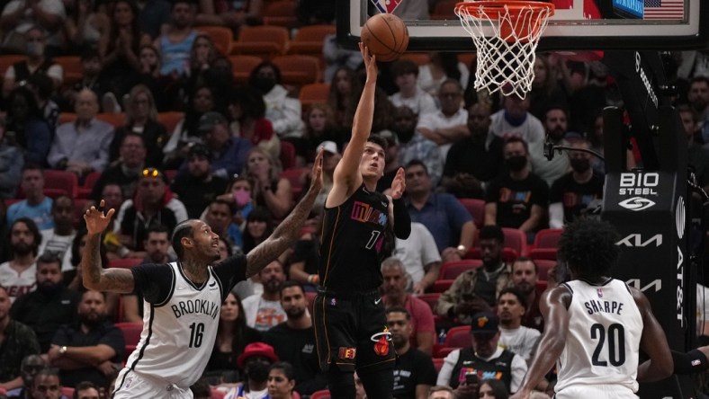 Feb 12, 2022; Miami, Florida, USA; Miami Heat guard Tyler Herro (14) shoots the ball around Brooklyn Nets forward James Johnson (16) during the first half at FTX Arena. Mandatory Credit: Jasen Vinlove-USA TODAY Sports