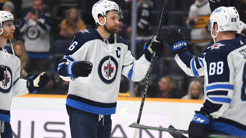 Feb 12, 2022; Nashville, Tennessee, USA; Winnipeg Jets right wing Blake Wheeler (26) celebrates with teammates after defeating the Nashville Predators at Bridgestone Arena. Mandatory Credit: Christopher Hanewinckel-USA TODAY Sports