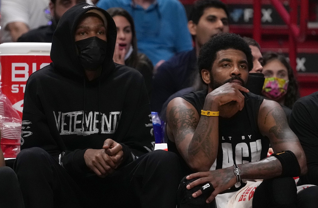 Feb 12, 2022; Miami, Florida, USA; Brooklyn Nets forward Kevin Durant (L) sits next to guard Kyrie Irving (11) during the second half against the Miami Heat at FTX Arena. Mandatory Credit: Jasen Vinlove-USA TODAY Sports