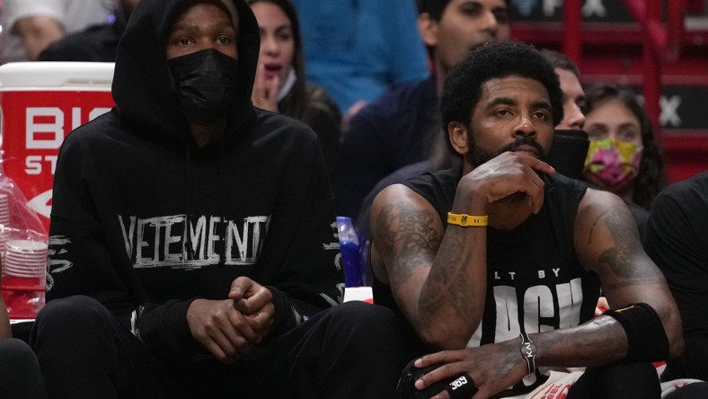 Feb 12, 2022; Miami, Florida, USA; Brooklyn Nets forward Kevin Durant (L) sits next to guard Kyrie Irving (11) during the second half against the Miami Heat at FTX Arena. Mandatory Credit: Jasen Vinlove-USA TODAY Sports