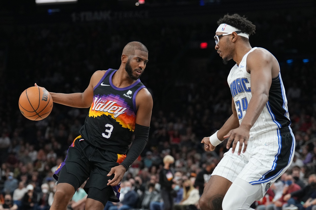 Feb 12, 2022; Phoenix, Arizona, USA; Phoenix Suns guard Chris Paul (3) dribbles against Orlando Magic center Wendell Carter Jr. (34) during the second half at Footprint Center. Mandatory Credit: Joe Camporeale-USA TODAY Sports