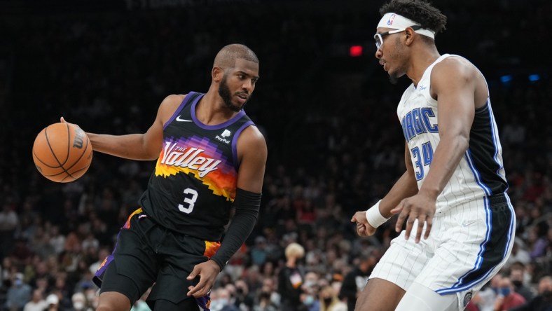 Feb 12, 2022; Phoenix, Arizona, USA; Phoenix Suns guard Chris Paul (3) dribbles against Orlando Magic center Wendell Carter Jr. (34) during the second half at Footprint Center. Mandatory Credit: Joe Camporeale-USA TODAY Sports