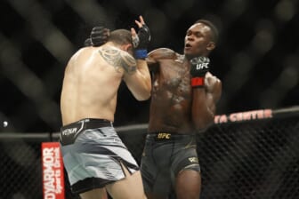 Feb 12, 2022; Houston, Texas, UNITED STATES; Israel Adesanya (red gloves) fights Robert Whittaker (blue gloves) during UFC 271 at Toyota Center. Mandatory Credit: Troy Taormina-USA TODAY Sports