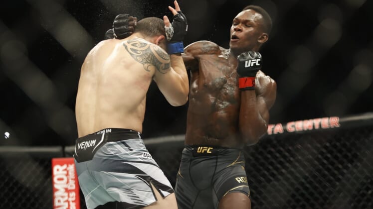 Feb 12, 2022; Houston, Texas, UNITED STATES; Israel Adesanya (red gloves) fights Robert Whittaker (blue gloves) during UFC 271 at Toyota Center. Mandatory Credit: Troy Taormina-USA TODAY Sports