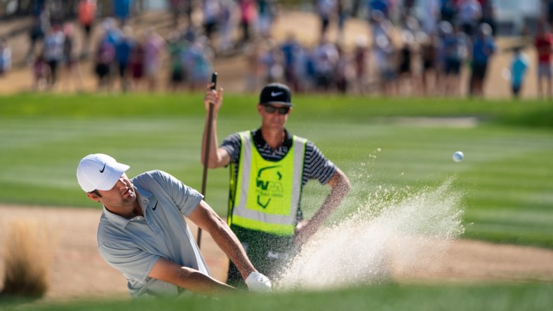 Feb 13, 2022; Scottsdale, Arizona, USA; Scottie Scheffler plays from the green side bunker on the third as caddy J.Tedd Scott looks on during the final round of the WM Phoenix Open golf tournament. Mandatory Credit: Allan Henry-USA TODAY Sports