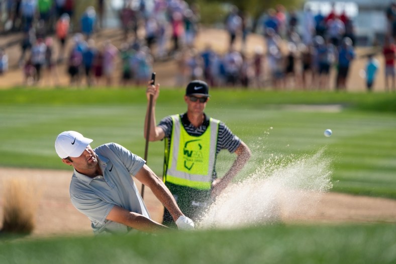 Feb 13, 2022; Scottsdale, Arizona, USA; Scottie Scheffler plays from the green side bunker on the third as caddy J.Tedd Scott looks on during the final round of the WM Phoenix Open golf tournament. Mandatory Credit: Allan Henry-USA TODAY Sports