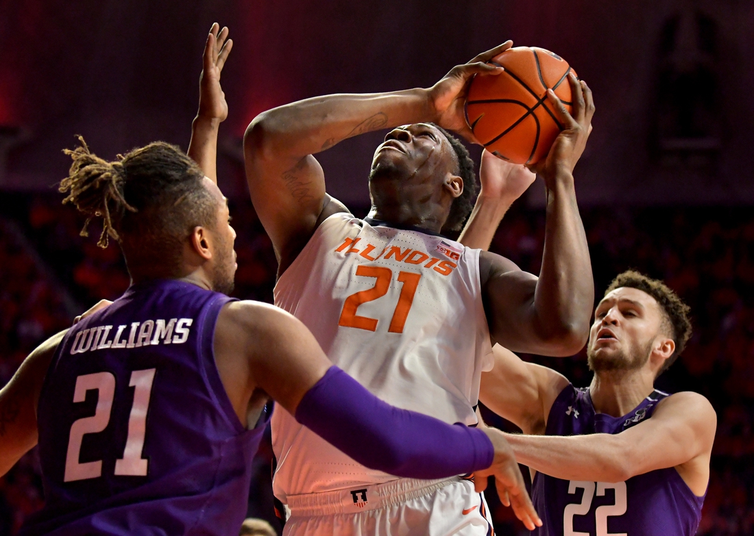 Feb 13, 2022; Champaign, Illinois, USA;  Northwestern Wildcats forward Elijah Williams (21) and teammate forward Pete Nance (22) guard Illinois Fighting Illini center Kofi Cockburn (21) as he drives to the basket during the first half at State Farm Center. Mandatory Credit: Ron Johnson-USA TODAY Sports