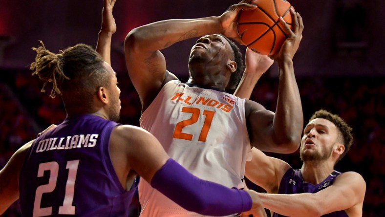 Feb 13, 2022; Champaign, Illinois, USA;  Northwestern Wildcats forward Elijah Williams (21) and teammate forward Pete Nance (22) guard Illinois Fighting Illini center Kofi Cockburn (21) as he drives to the basket during the first half at State Farm Center. Mandatory Credit: Ron Johnson-USA TODAY Sports