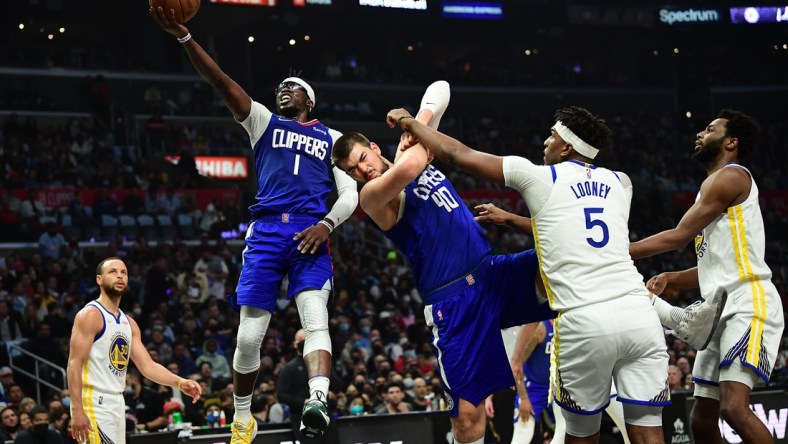 Feb 14, 2022; Los Angeles, California, USA; Los Angeles Clippers guard Reggie Jackson (1) moves to the basket as center Ivica Zubac (40) provides coverage against Golden State Warriors center Kevon Looney (5) during the first half at Crypto.com Arena. Mandatory Credit: Gary A. Vasquez-USA TODAY Sports