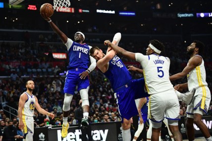 Feb 14, 2022; Los Angeles, California, USA; Los Angeles Clippers guard Reggie Jackson (1) moves to the basket as center Ivica Zubac (40) provides coverage against Golden State Warriors center Kevon Looney (5) during the first half at Crypto.com Arena. Mandatory Credit: Gary A. Vasquez-USA TODAY Sports