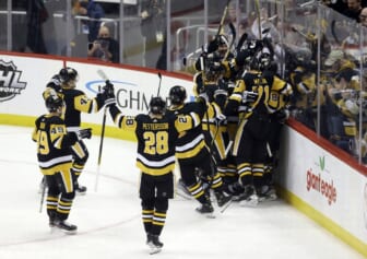 Feb 15, 2022; Pittsburgh, Pennsylvania, USA;  Pittsburgh Penguins center Sidney Crosby (hiden) is mobbed by teammates after Crosby scored his 500th career NHL goal against the Philadelphia Flyers during the first period at PPG Paints Arena. Mandatory Credit: Charles LeClaire-USA TODAY Sports